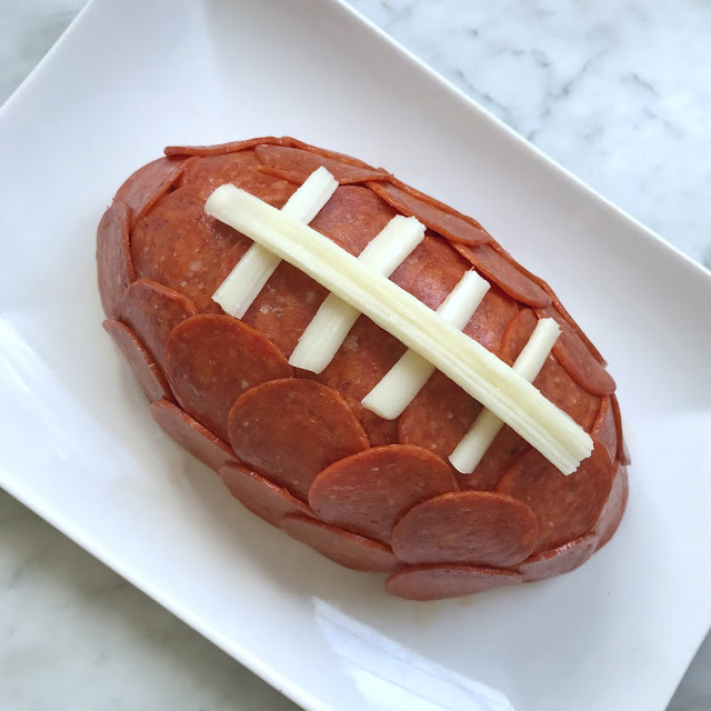 super easy football party food ideas - football cheese ball with pepperoni and string cheese