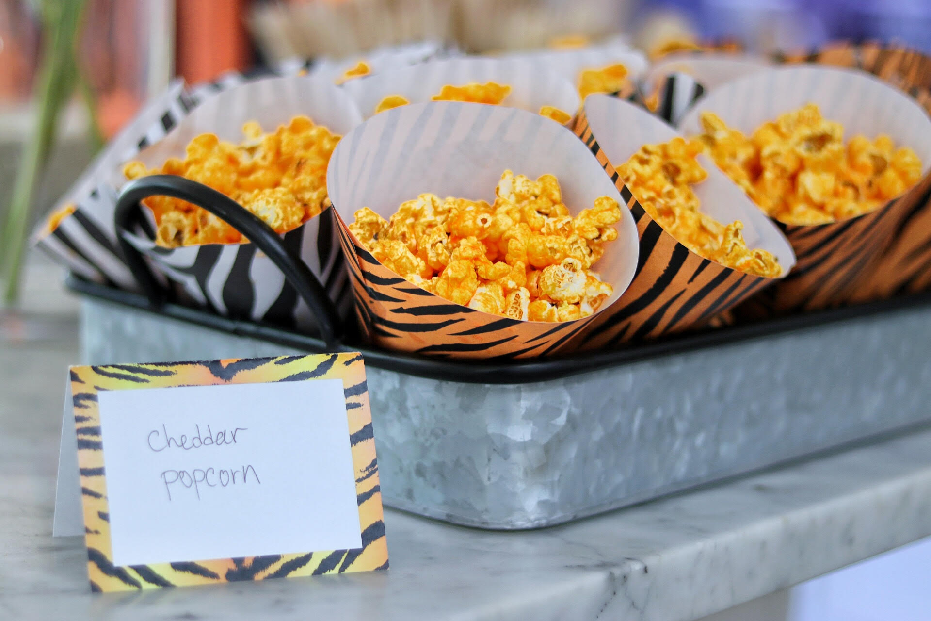 cheddar popcorn for a tiger party food idea, served in free printable party cones