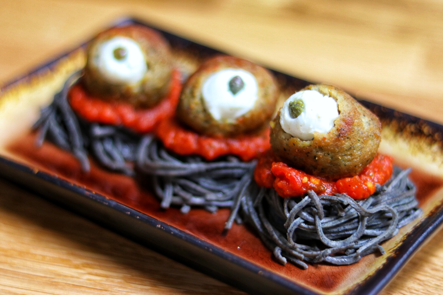 easy halloween food ideas: eyeball meatballs spooky spaghetti with black bean noodles