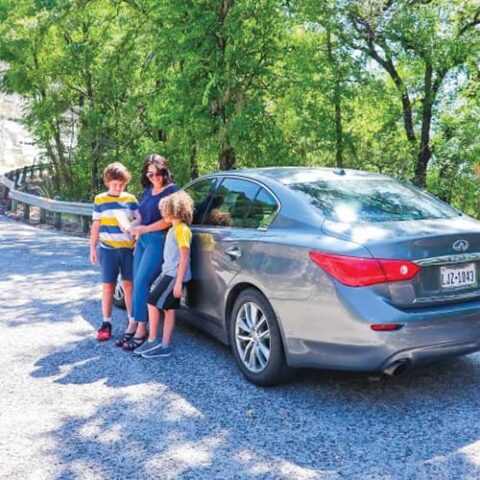 ramona and children standing in front of car.